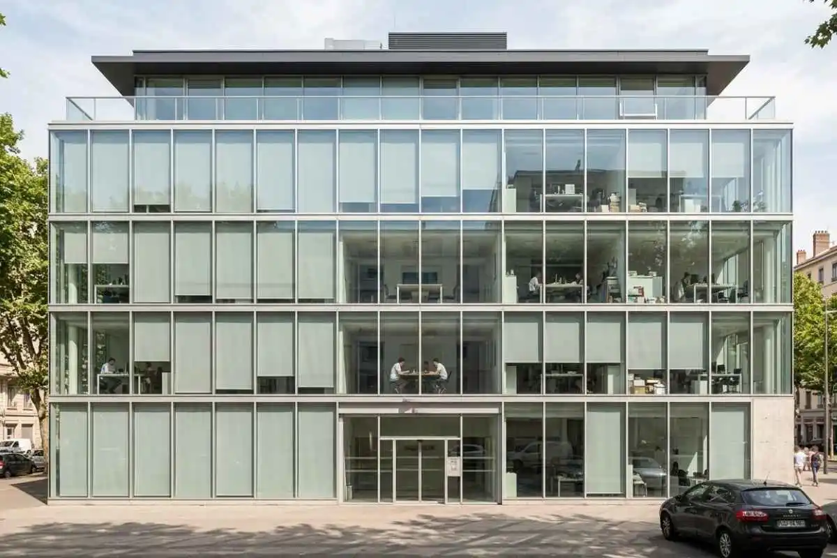 Façade vitrée d'un immeuble de bureaux tertiaire avec toiture plate exposée au soleil