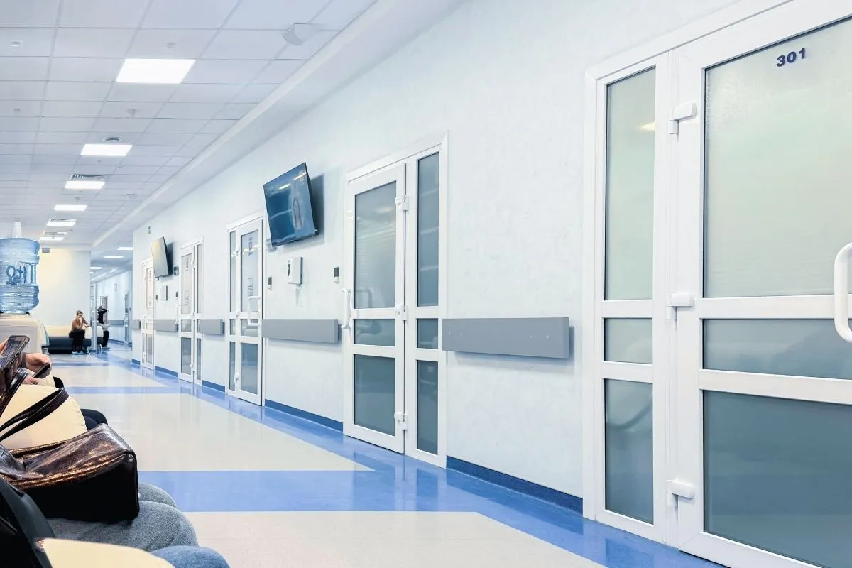 Établissement de santé exposé au soleil en été, montrant un bâtiment public vulnérable à la chaleur.